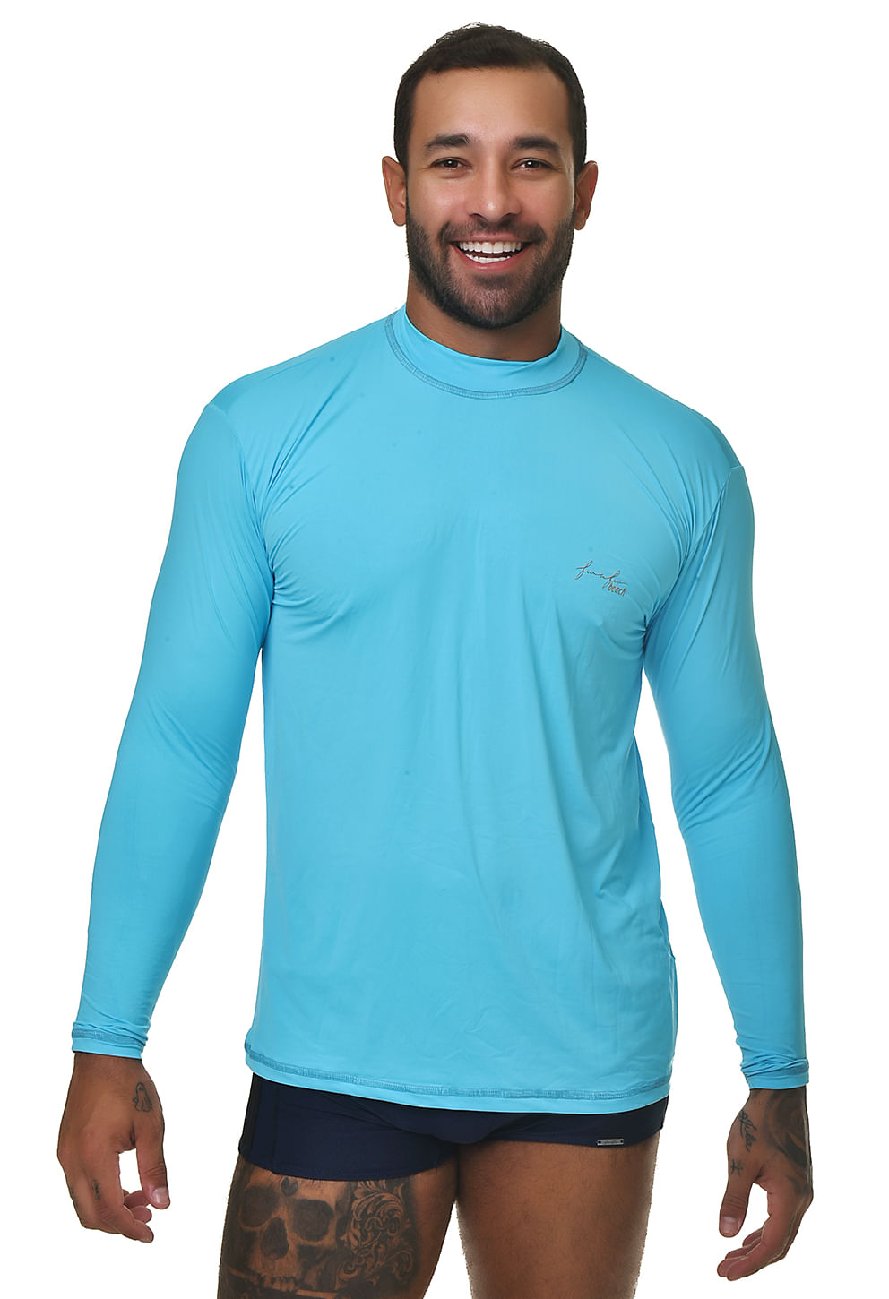 Homem em pé usando camisa de proteção UV manga longa azul claro, gola careca, corte reto levemente ajustado