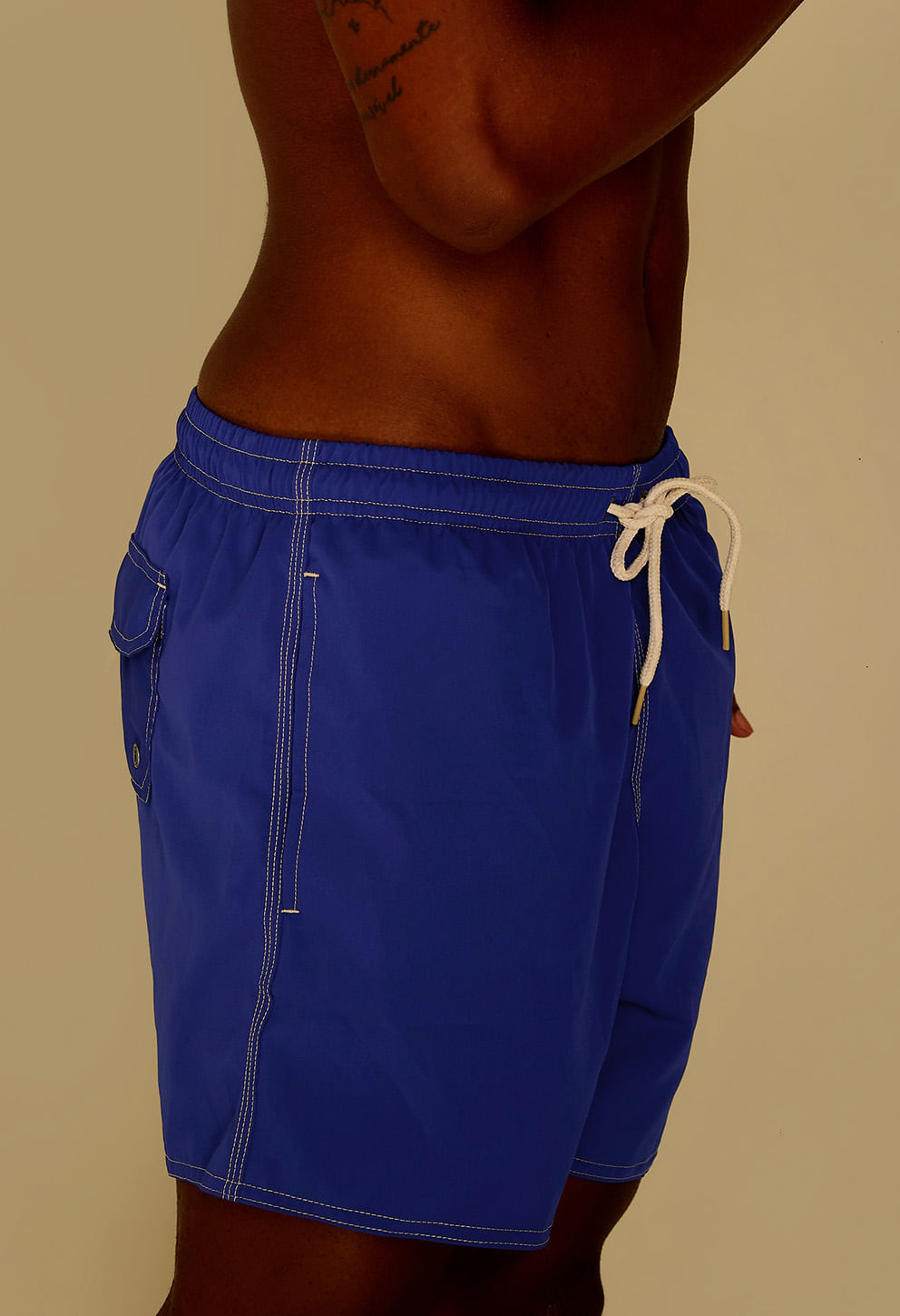 Close lateral da bermuda azul bic mostrando cordão branco e bolso lateral