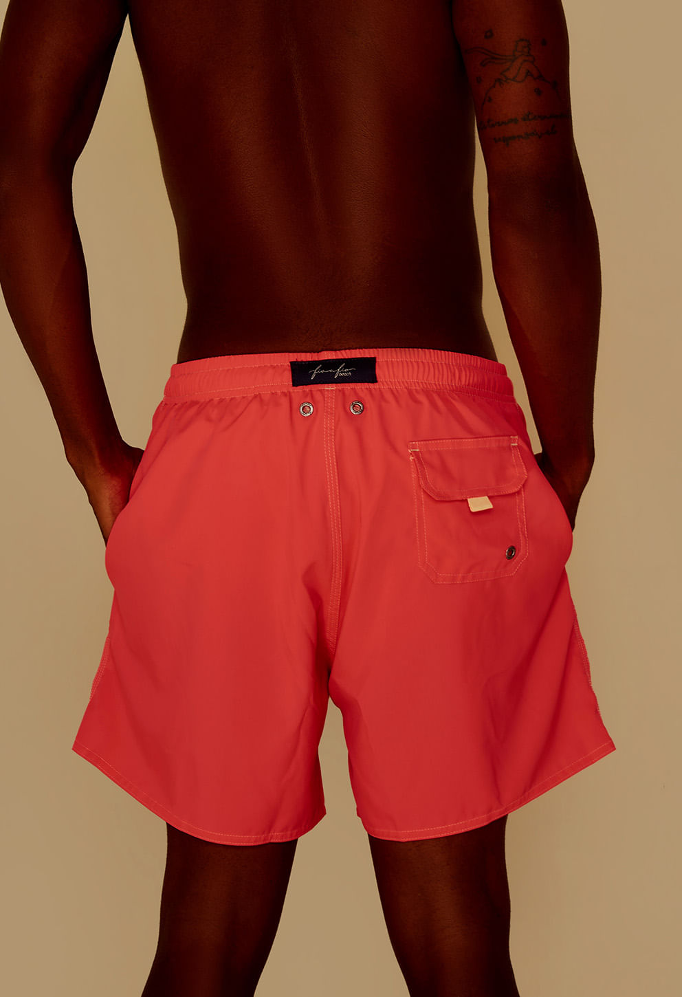 Visão traseira da bermuda pink mostrando bolso com aba e ilhós metálicos