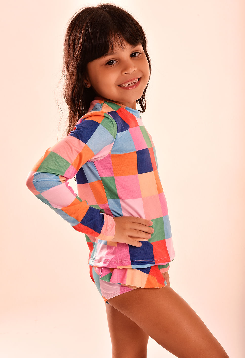 Perfil lateral mostrando caimento e acabamento da camisa infantil quadriculada
