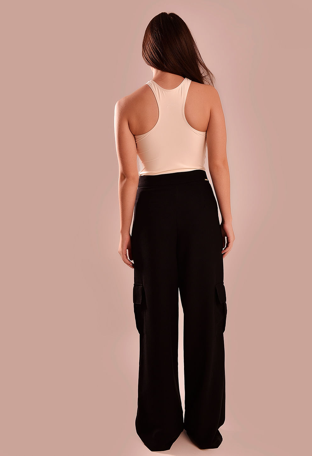 Vista traseira da calça pantalona preta mostrando bolsos laterais estilo cargo e caimento.