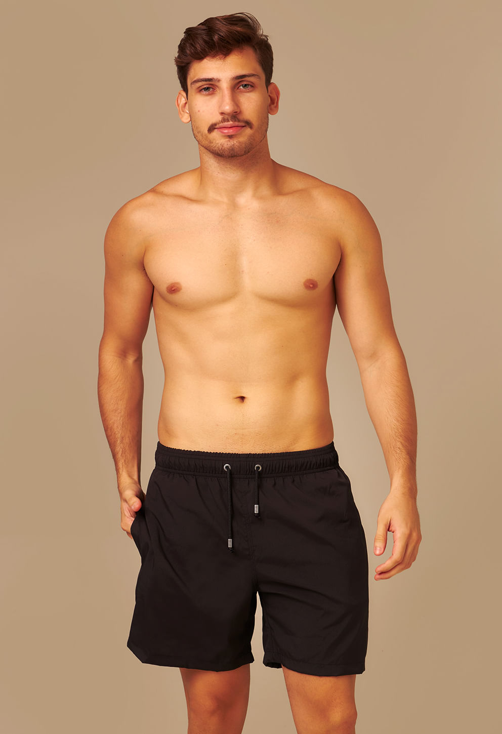 Modelo masculino vestindo bermuda preta com cós elástico, cordão ajustável e bolsos laterais