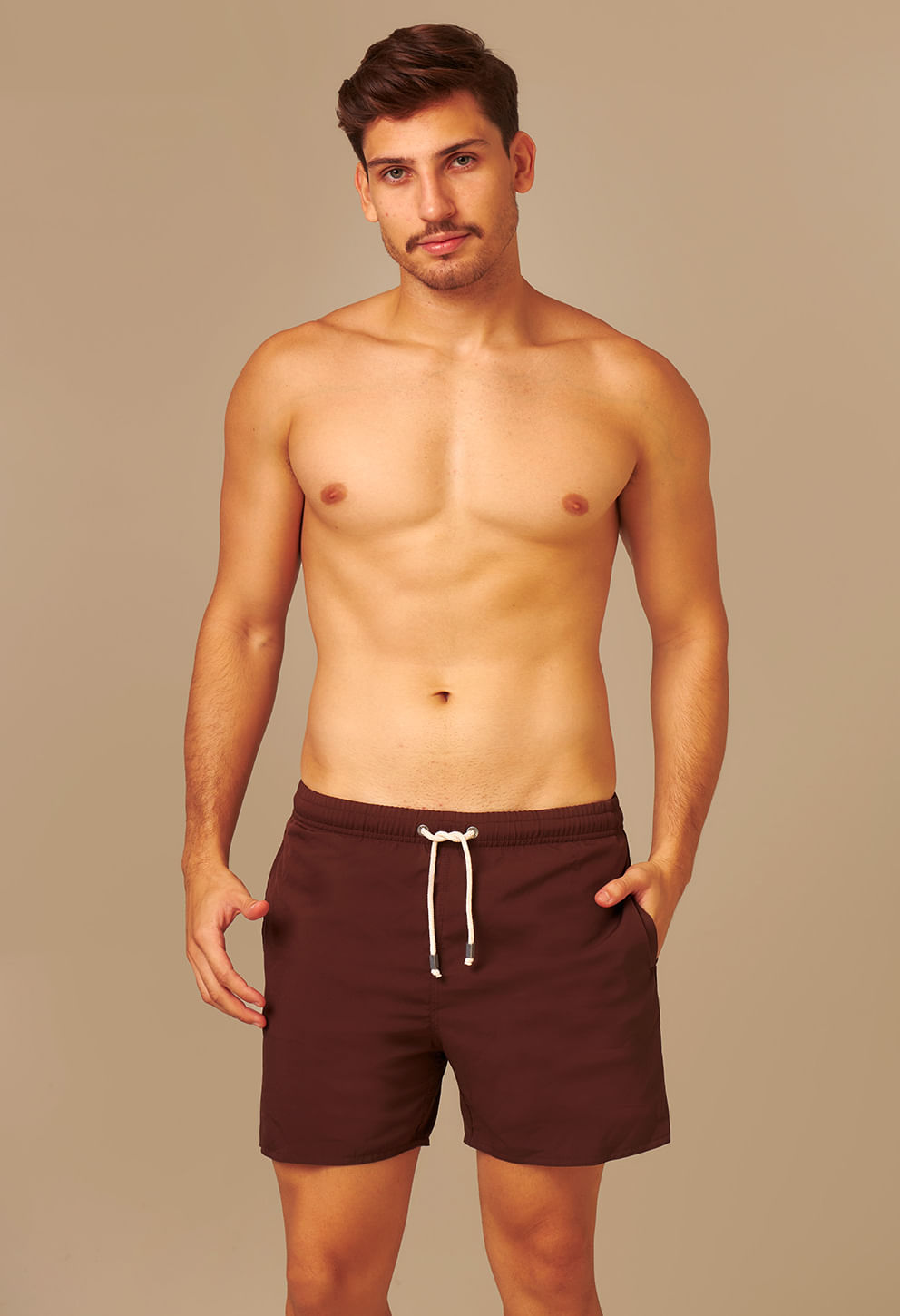 Modelo usando bermuda casual Marrom Café com cós elástico e cordão branco, fundo bege
