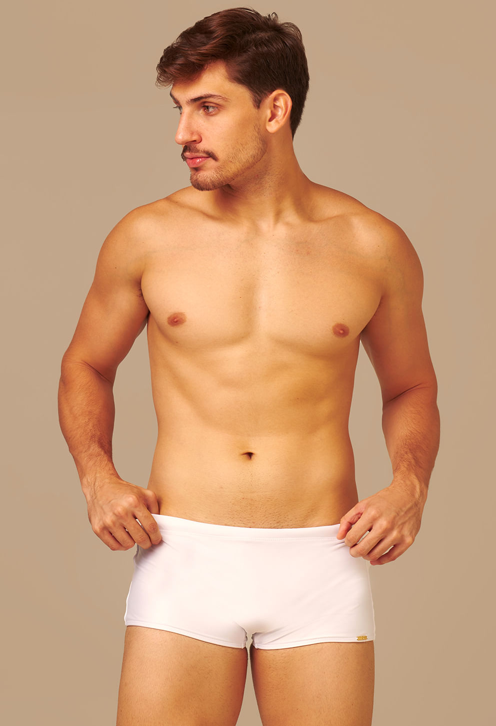 Frontal de homem usando sunga short adulto branca com fundo bege