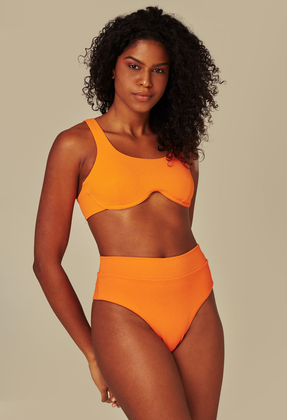 Modelo usando Calcinha Frésia Aperol laranja, cintura alta e tecido texturizado