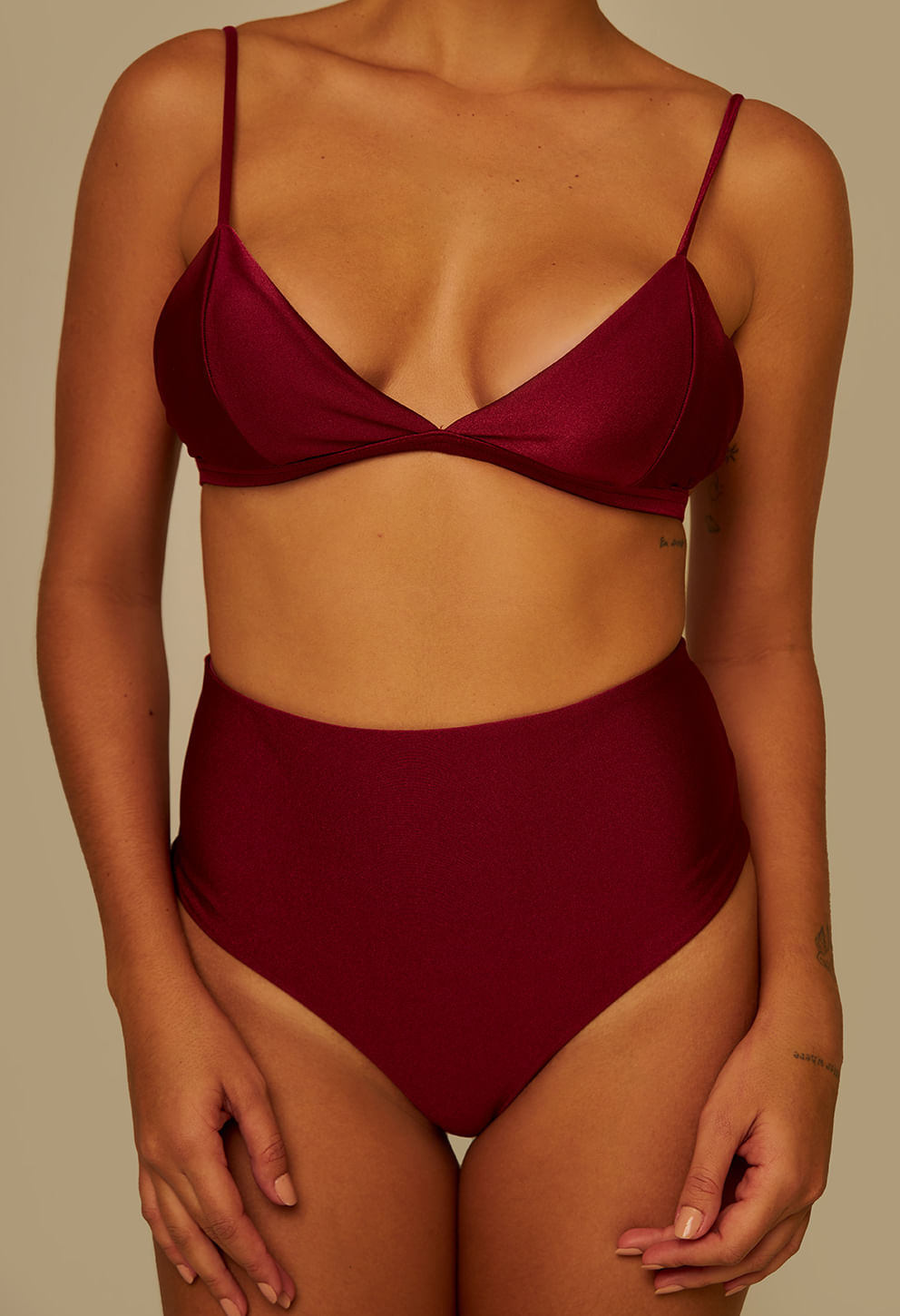Close frontal da modelo destacando detalhes do tecido acetinado da calcinha hot pant vinho