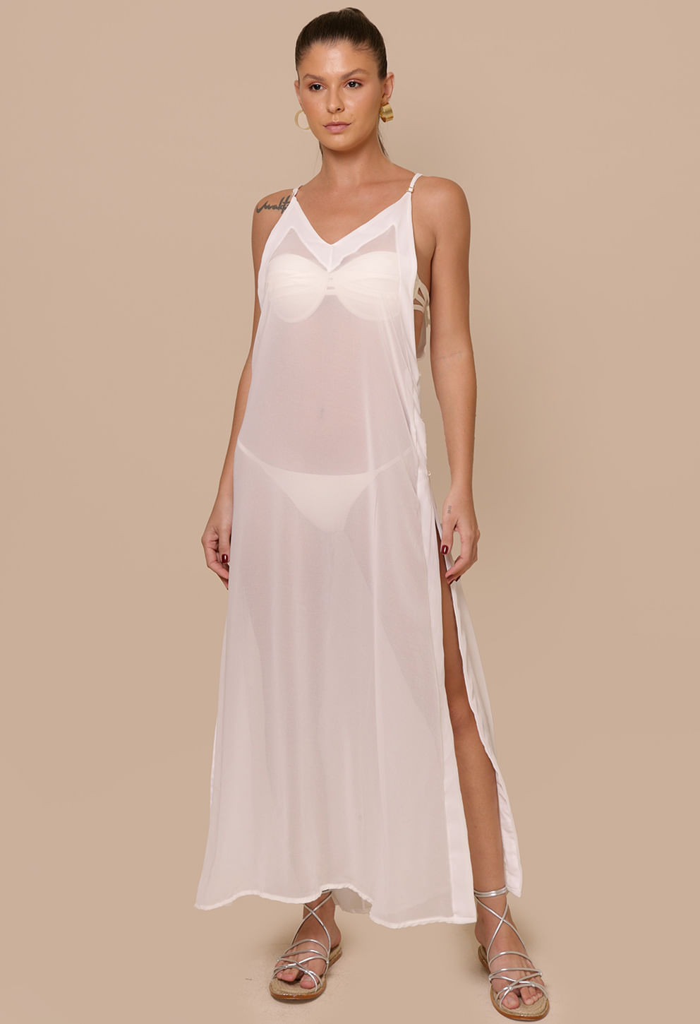Modelo usando saída de praia longa off-white com decote em V e fenda lateral