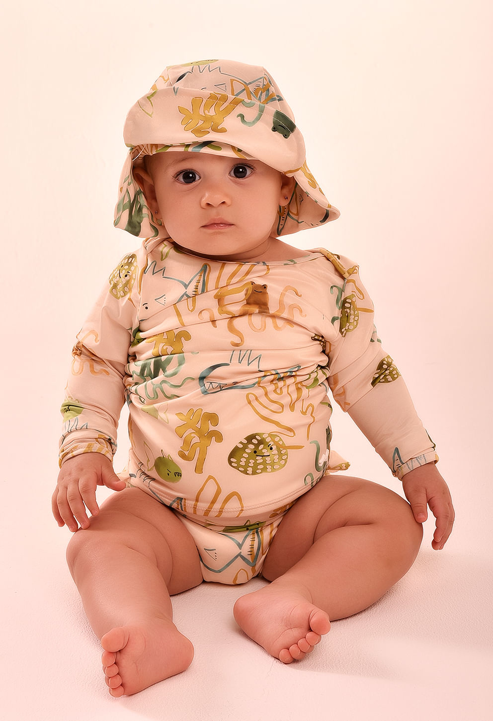 Bebê sentado usando camisa manga longa tipo body com estampa marinha rosé/areia