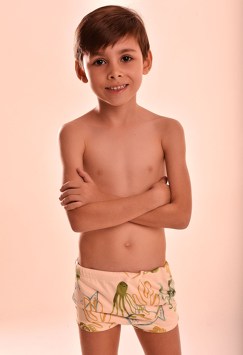 Garoto infantil posando com sunga short Nemo bege claro com estampa de animais marinhos