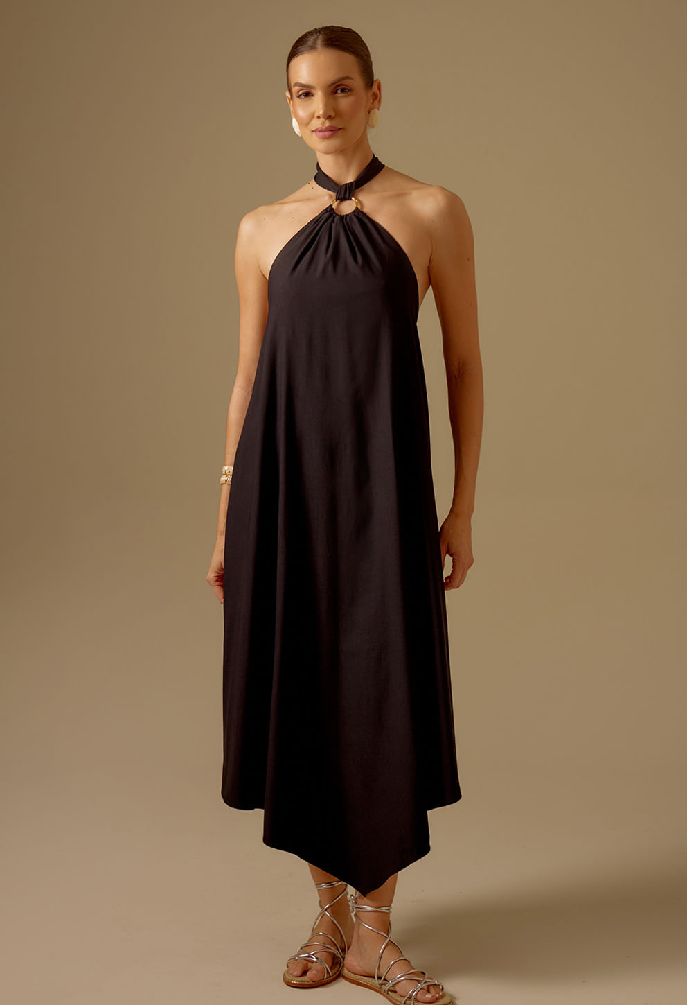 Vestido Jaque preto com decote halter e argola dourada, caimento fluido e barra assimétrica