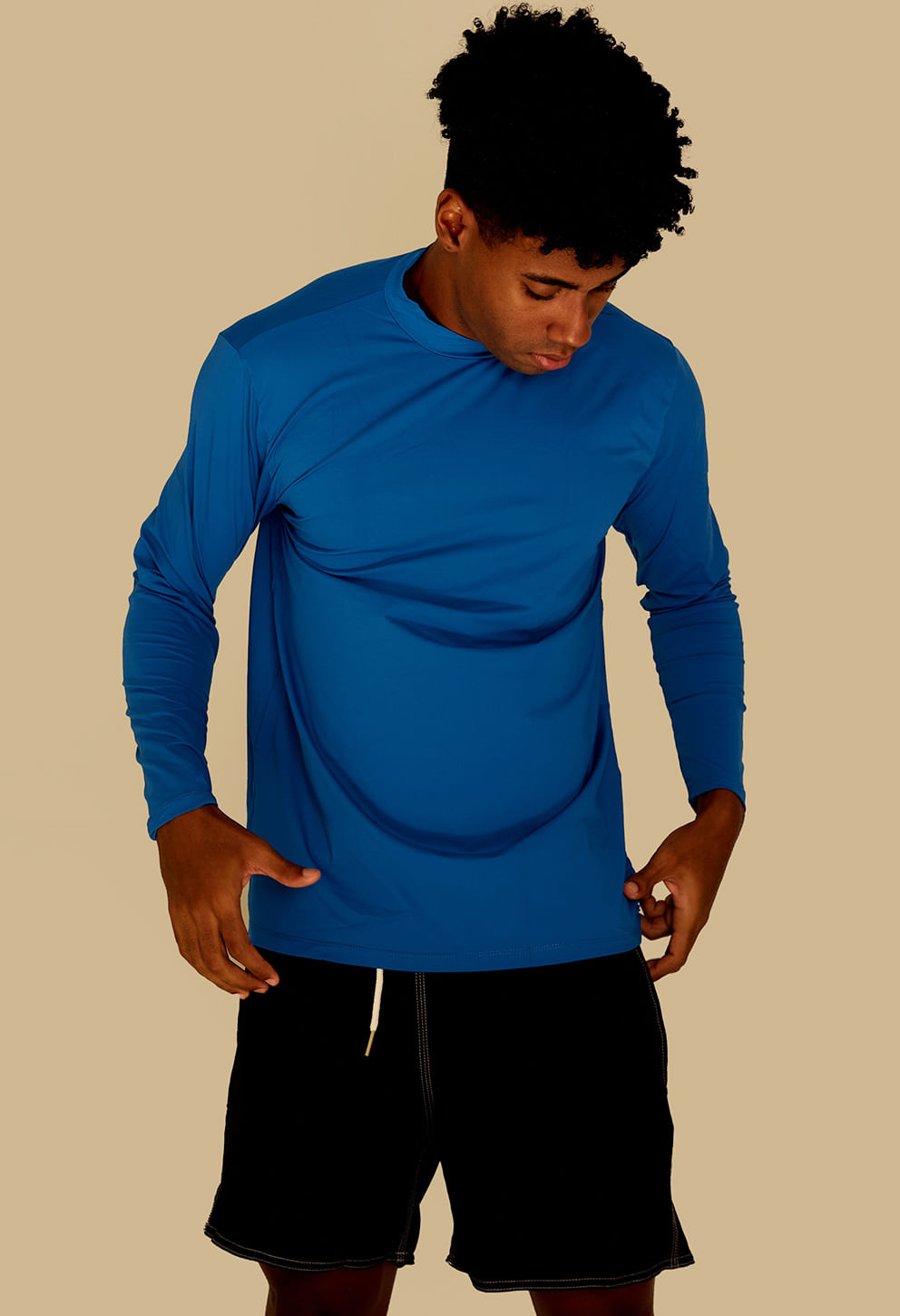 Homem usando camisa UV azul royal manga longa, caimento reto