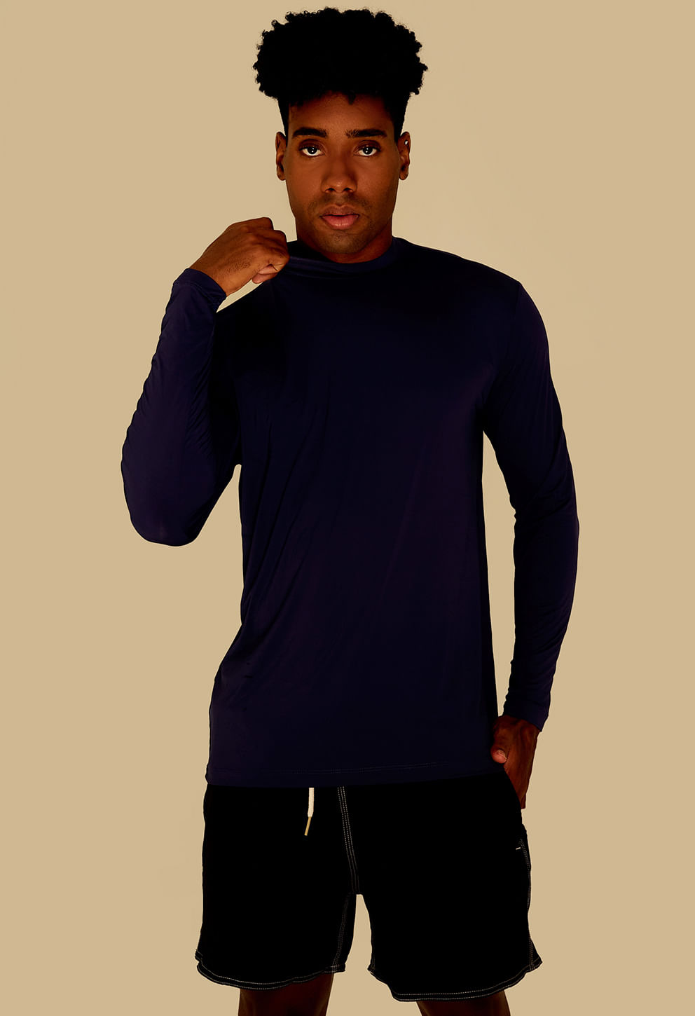 Modelo masculino vestindo camisa UV de manga longa na cor marinho, gola alta discreta, caimento justo/reto