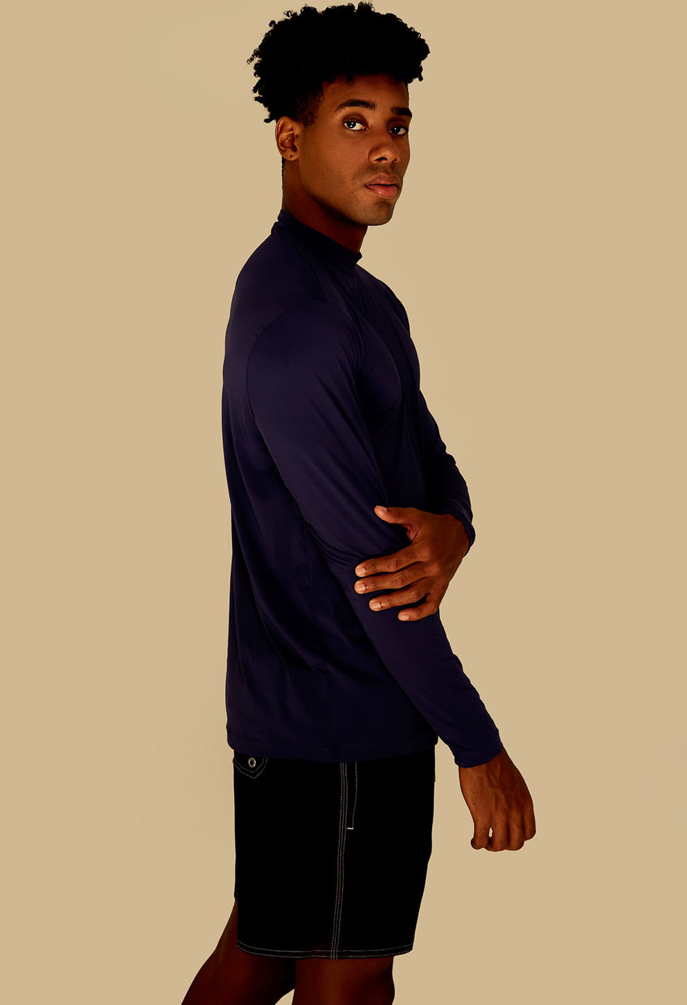 Visão lateral do modelo usando camisa UV marinho mostrando detalhes do ombro e caimento