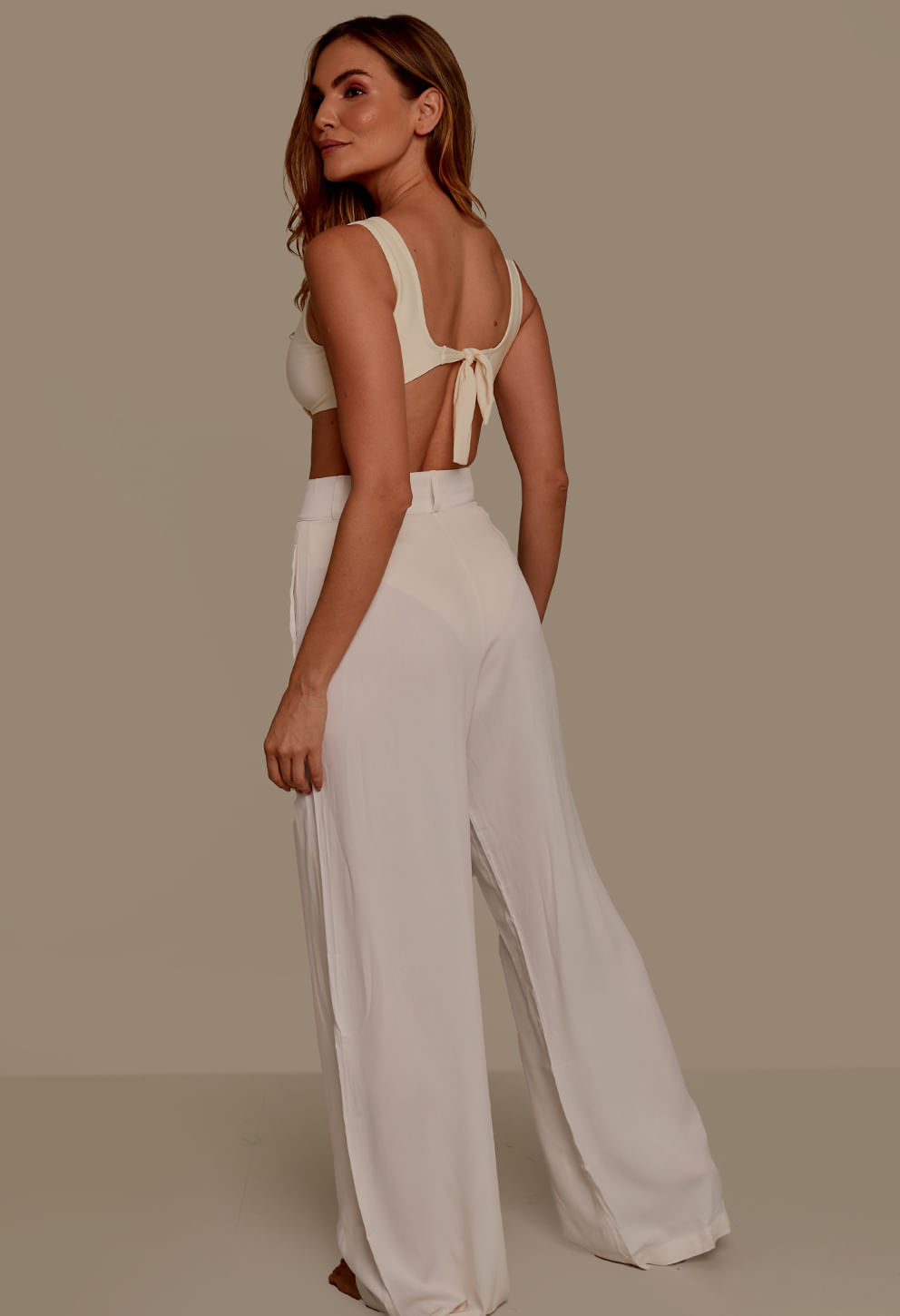 Calça pantalona social branca lateral mostrando o caimento fluido
