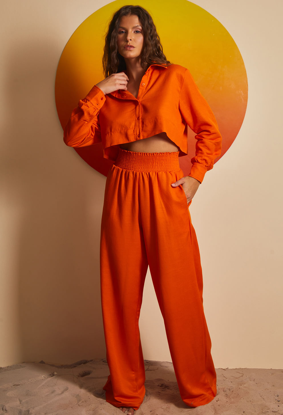 Cropped laranja de manga longa com botões, gola tradicional e corte curto acima da cintura