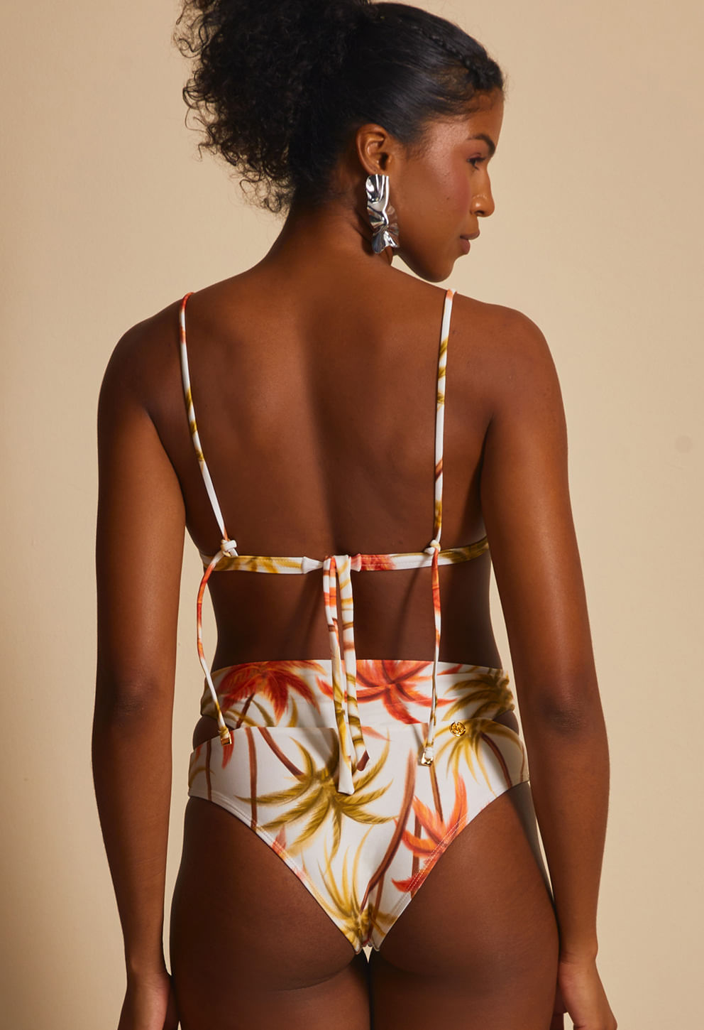 Parte traseira da Calcinha Mary Caraiva com estampa de folhas laranja e verde