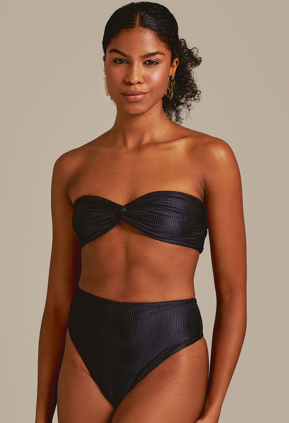 Modelo usando Calcinha Hot Beatriz Édem Preto, cintura alta, tecido texturizado com brilho discreto.
