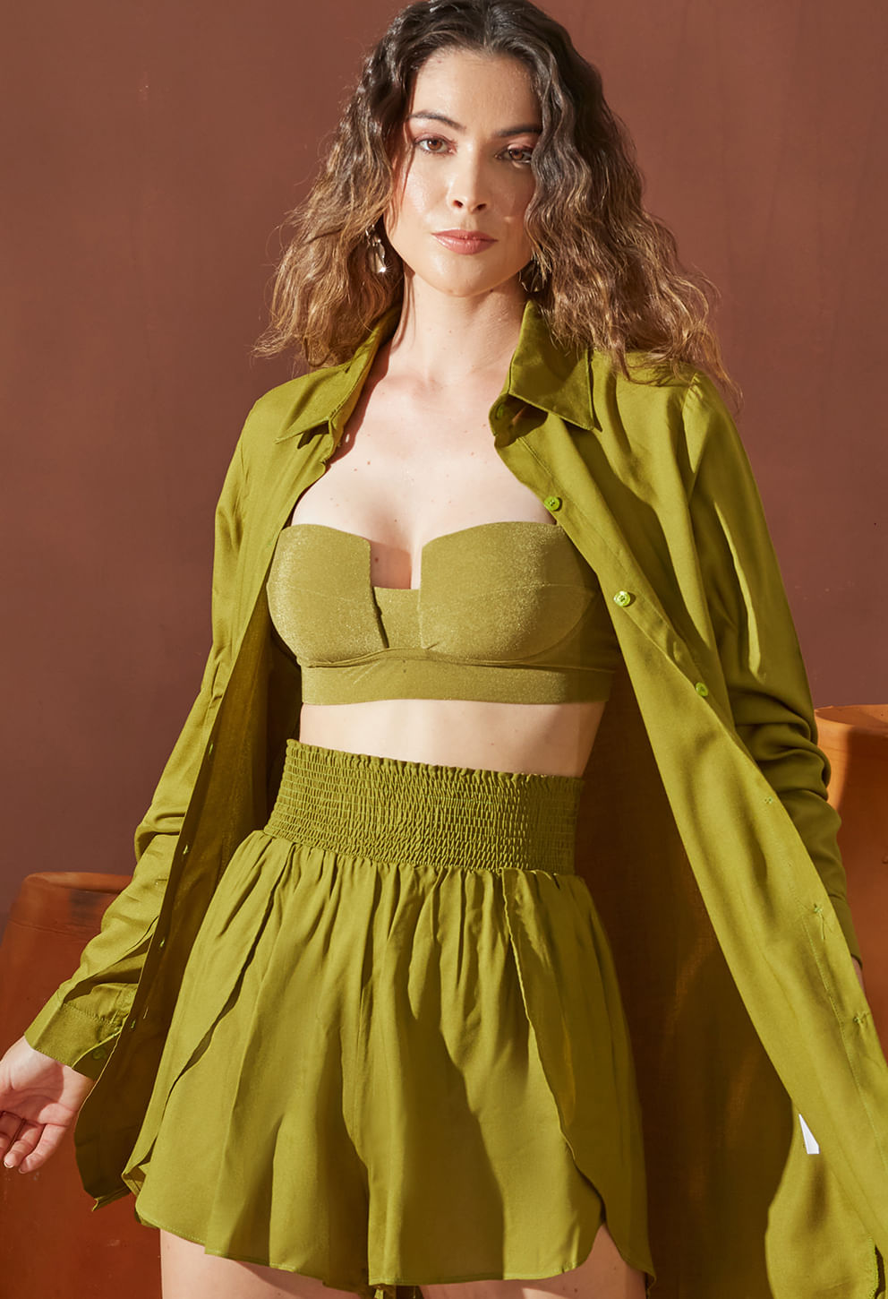 Short transpassado verde combinado com top e camisa aberta, visual casual e elegante