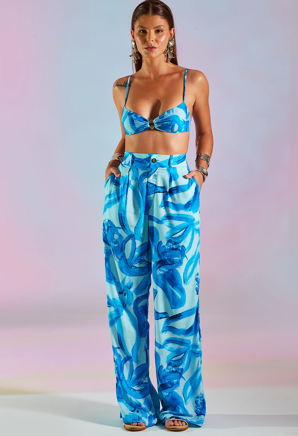Modelo usando Top Karina com Aviamento Oceania azul, detalhe dourado na frente
