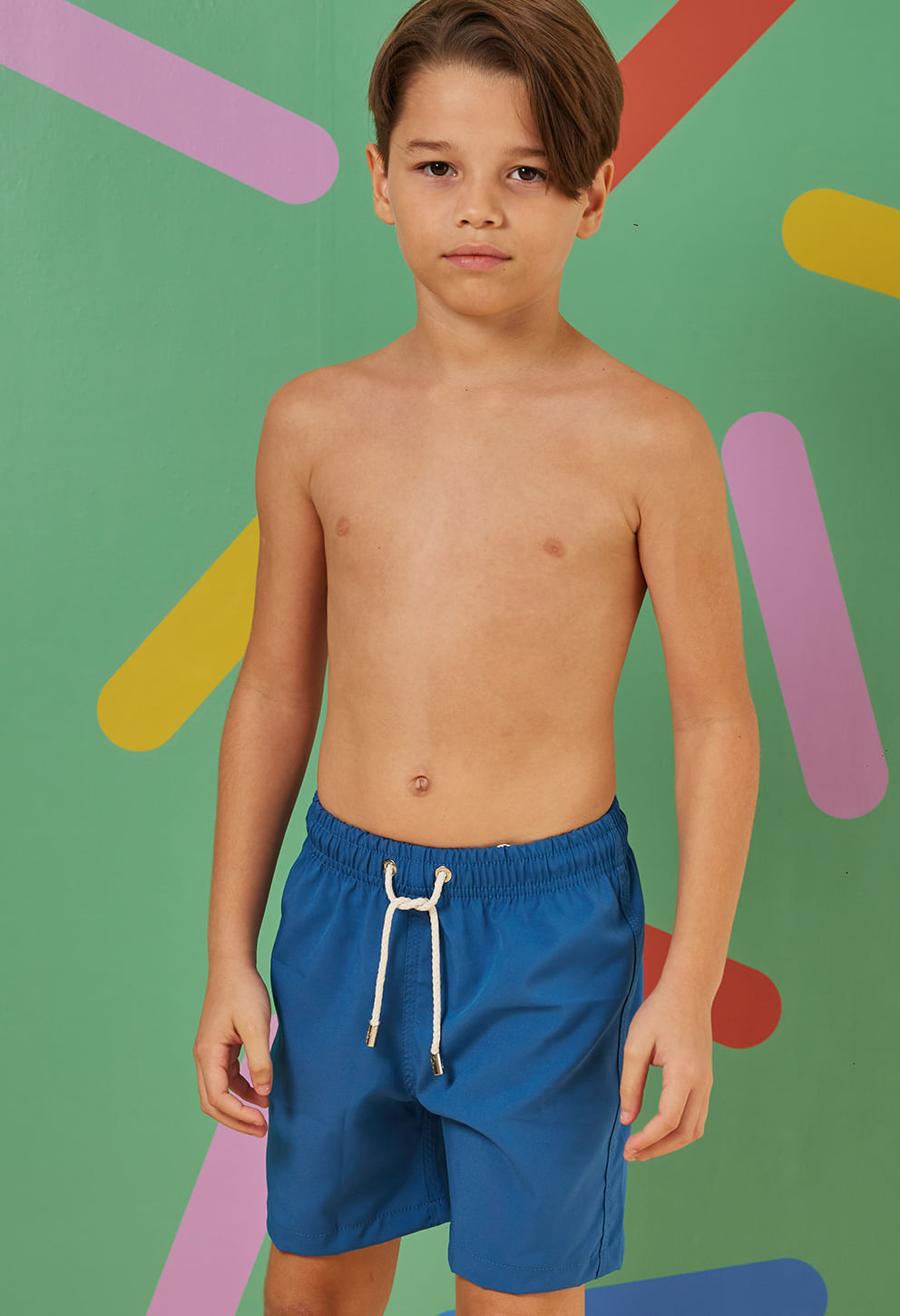 Menino usando bermuda azul royal com elástico e cordão branco, bolso traseiro