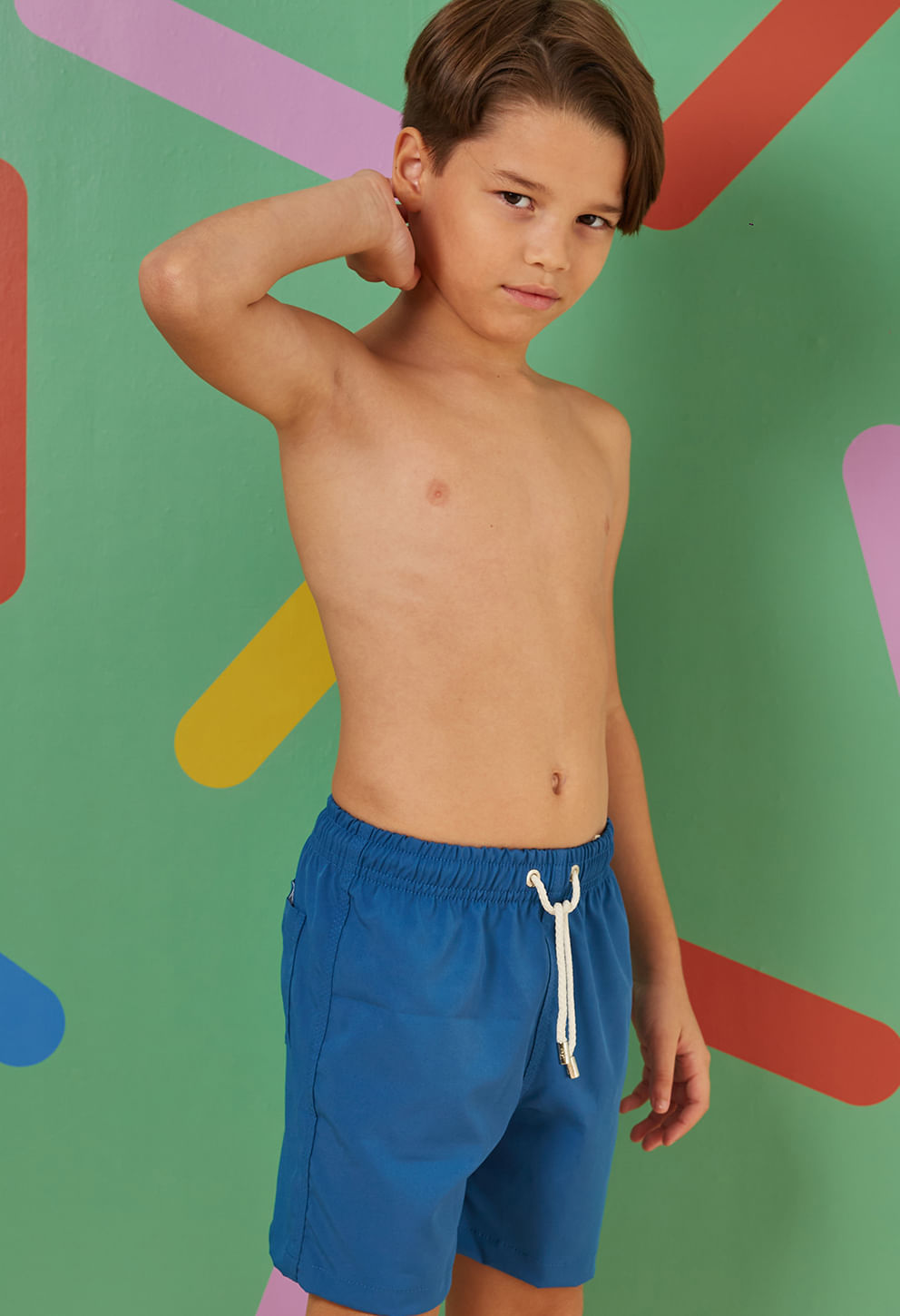 Menino em pose casual usando bermuda azul royal com cordão branco