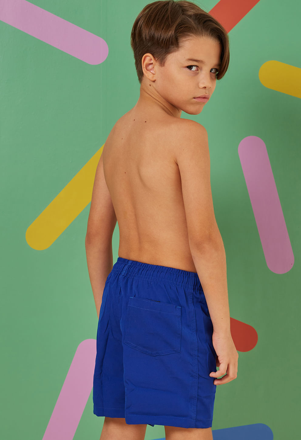 Menino visto de costas usando bermuda infantil azul bic com bolso traseiro