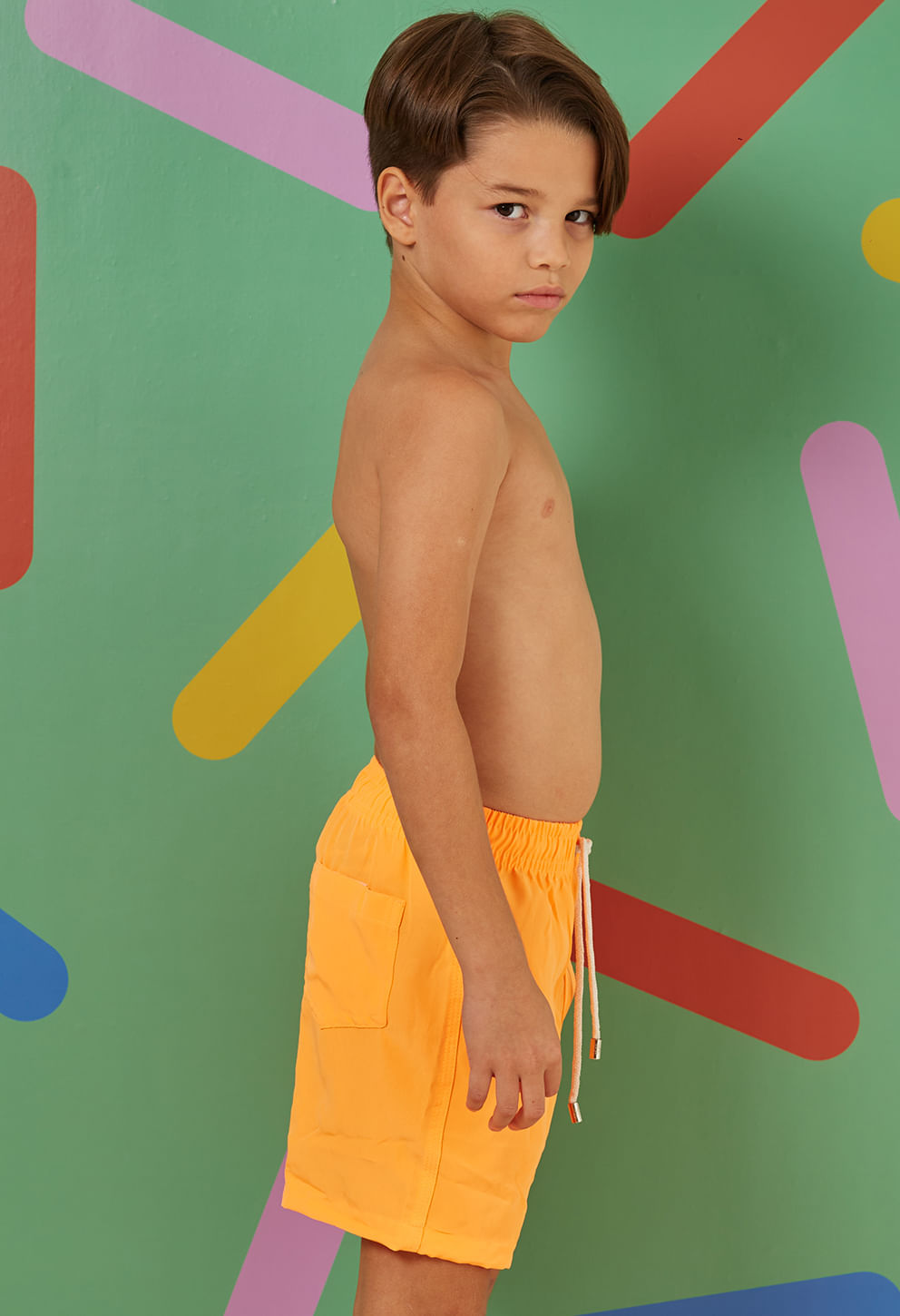 Perfil da bermuda infantil laranja flúor com bolso traseiro e cordão branco