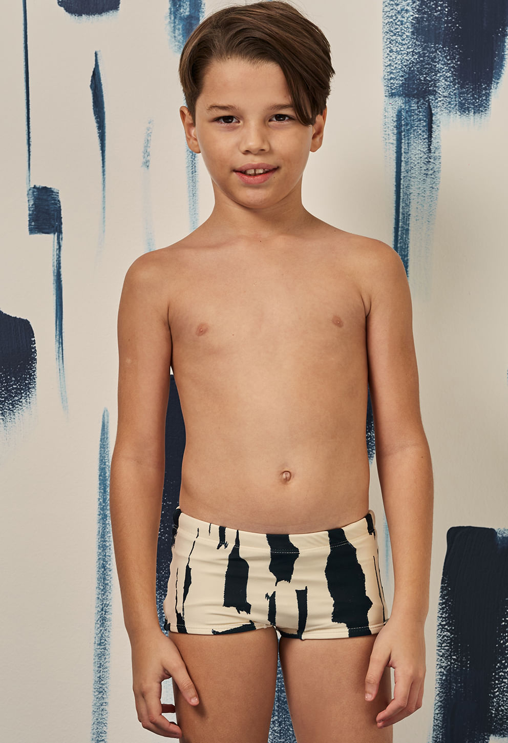 Garoto usando sunga short Índico creme com listras pretas, frontal