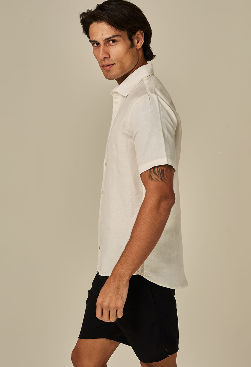 Modelo de perfil usando bermuda casual shortinho preta, vista lateral