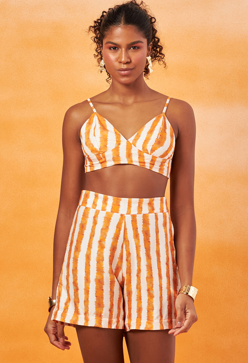 Modelo usando Top Livia Dunas listrado em laranja e branco, vista frontal