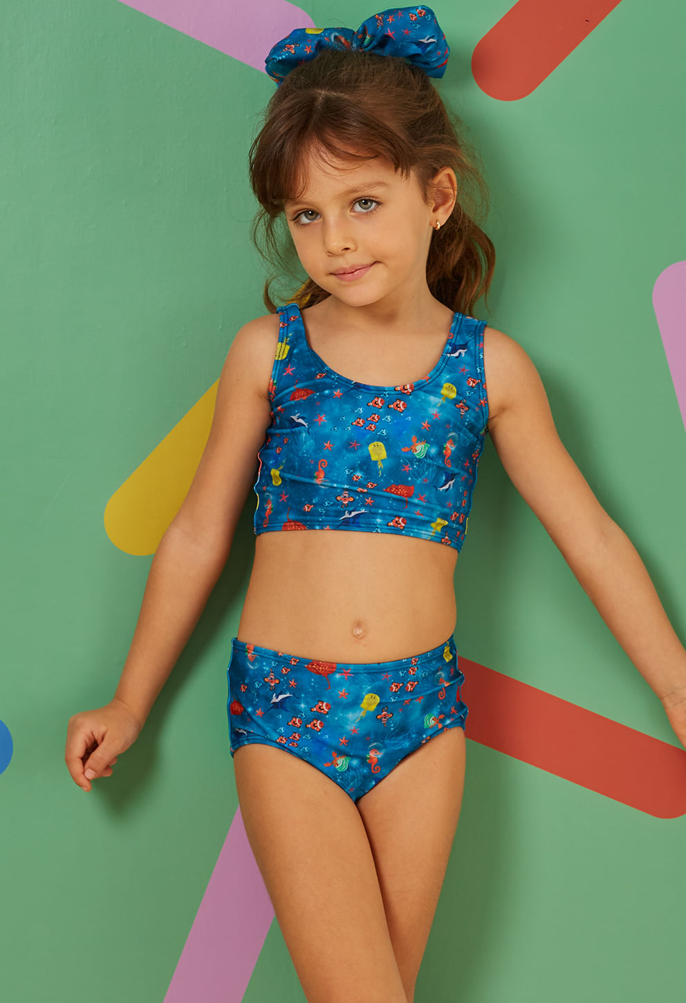 Menina vestindo biquíni infantil Pietra Aventura Marítima azul com estampa marítima colorida