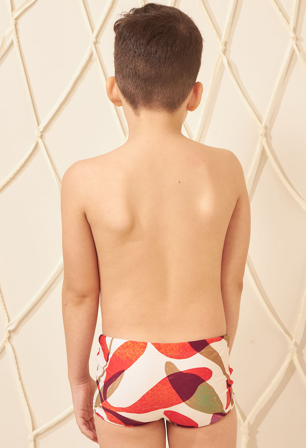 Costas da sunga short infantil mostrando a estampa colorida e corte reto