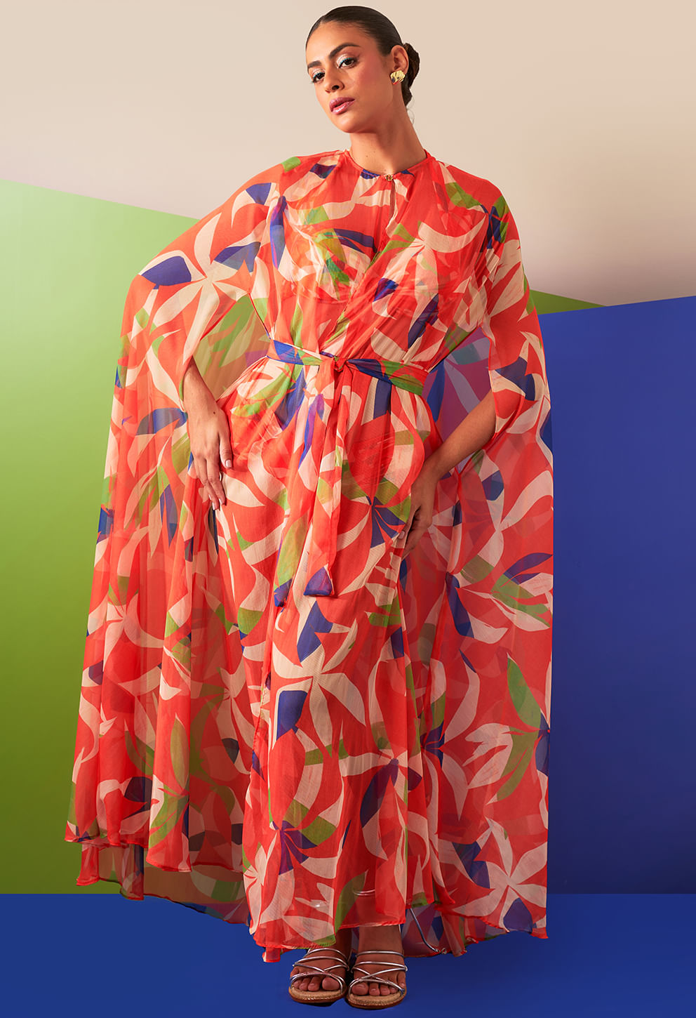 Modelo veste saída de praia longa transparente com estampa floral em vermelho, azul, verde e branco