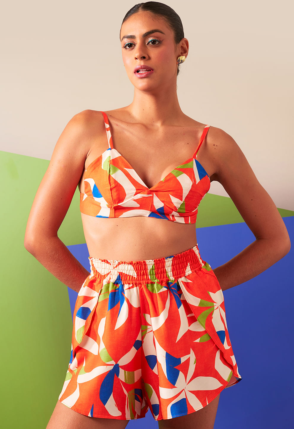 Short Malu Verano laranja com estampa floral abstrata, cós elástico e bolsos laterais.