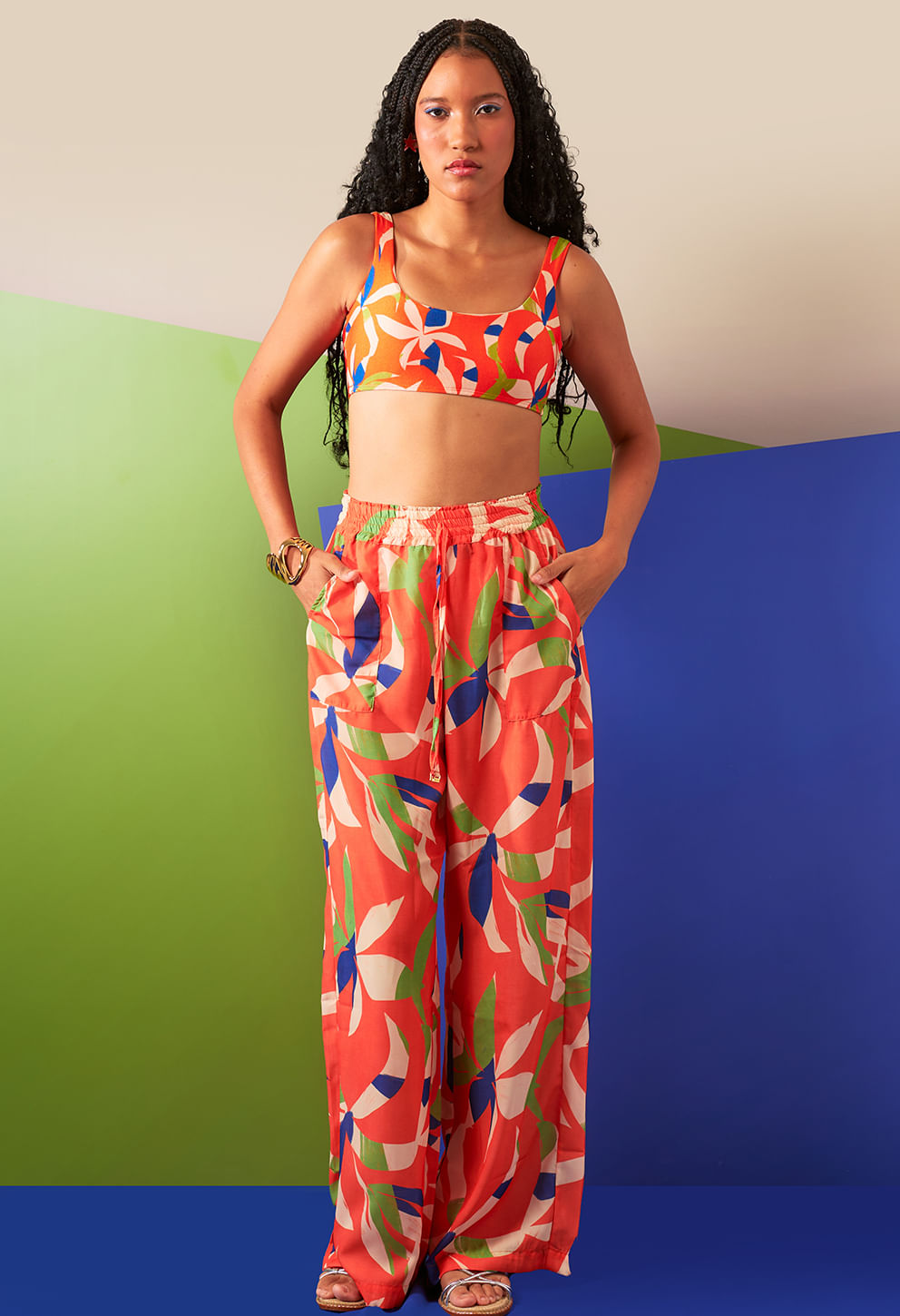 Modelo usando Calça Bela Verano com estampa floral laranja, cós elástico e bolsos