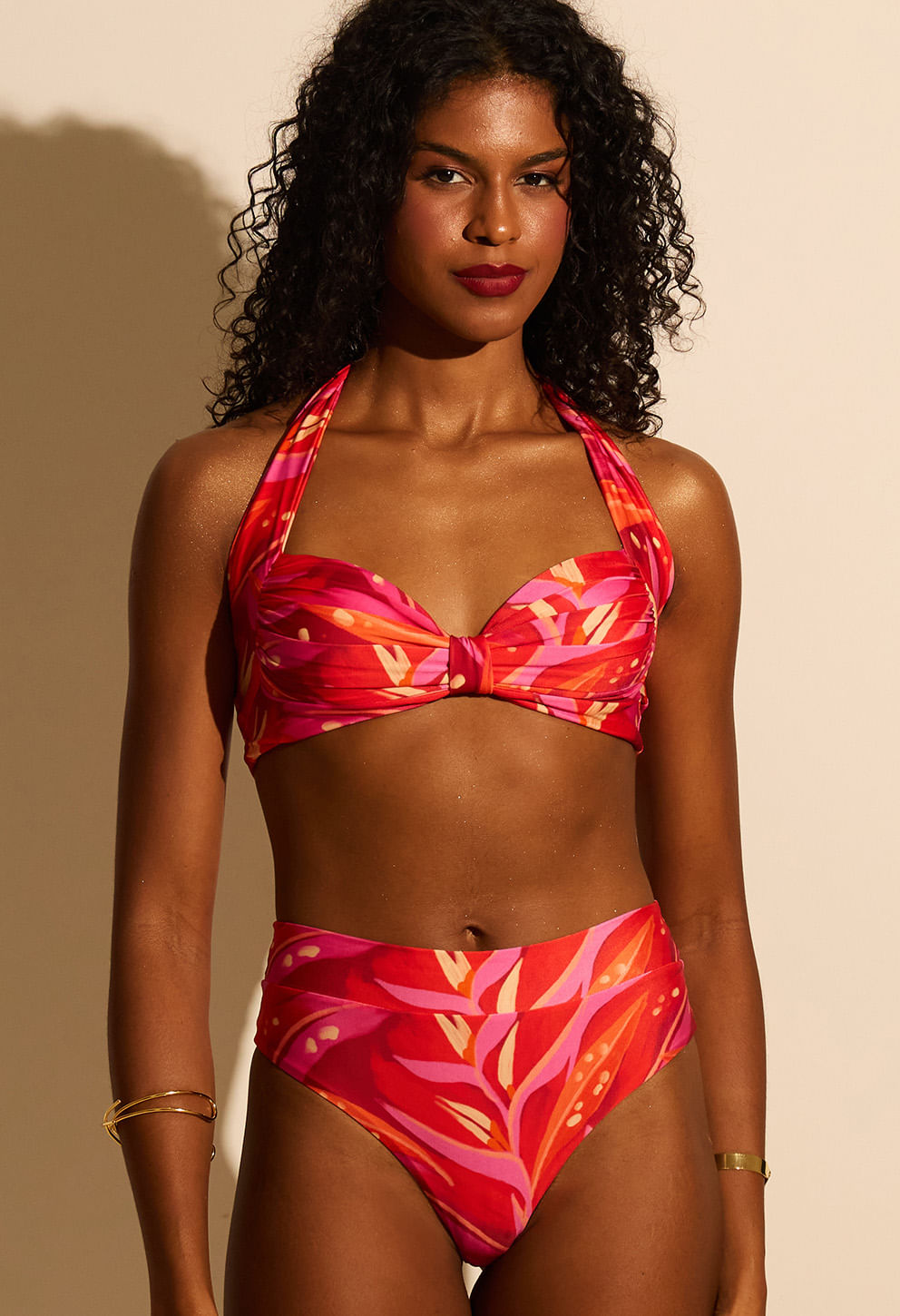 Mulher negra usando calcinha hot pant rosa com estampa tropical, cós alto e ajuste confortável