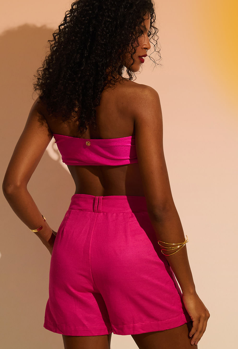 Visão traseira do Short Lua Flora rosa vibrante destacando pregas e detalhe do top
