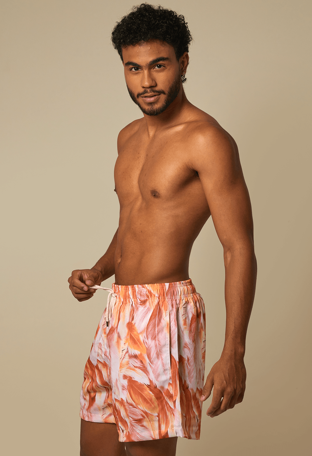 Modelo masculino exibindo bermuda Shortinho Brisa Doce em vista lateral, ajustando o cordão branco do cós elástico.