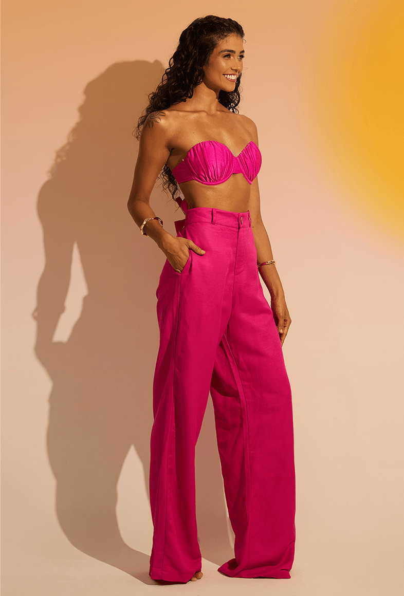 Modelo usando Calça Pantalona Malu Flora rosa, vista lateral com bolso e cintura alta