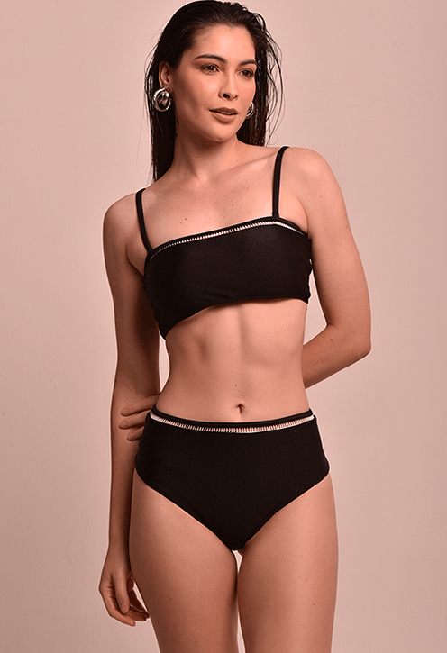 Modelo feminino em pé, vestindo calcinha hot preta com entremeio claro na cintura. Vista frontal da peça.