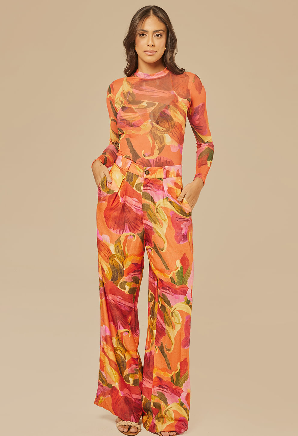 Modelo feminina usando blusa segunda pele de manga longa com estampa floral em tons de laranja, rosa, amarelo e verde