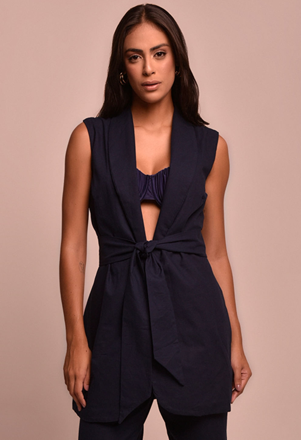 Colete feminino azul marinho sem mangas com gola blazer e faixa amarrada na cintura, comprimento médio