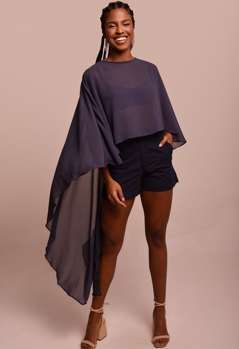 Modelo feminino usando blusa longa assimétrica náutica em tecido fluido semitransparente na cor azul marinho/índigo.