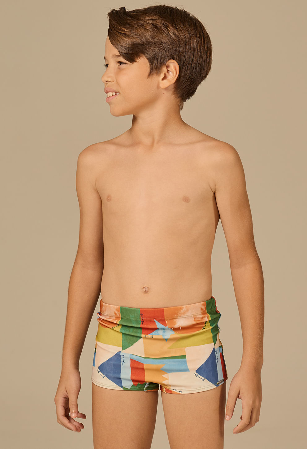 Menino vestindo sunga short infantil Balão Mágico com estampa colorida