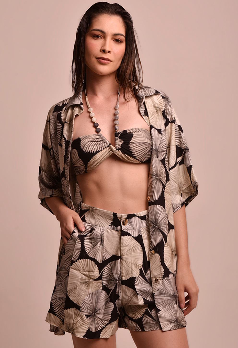 Foto frontal do conjunto: camisão usado aberto sobre top torcido e shorts combinando; estampa de mandalas creme/bege sobre fundo preto. Detalhes visíveis: botões frontais, bolsos laterais no short e