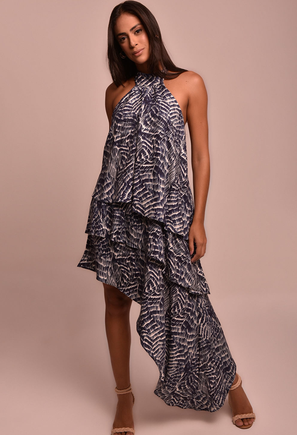 Modelo veste o Vestido Jamile Maré Alta, estampa abstrata azul marinho e branco, comprimento assimétrico com babados