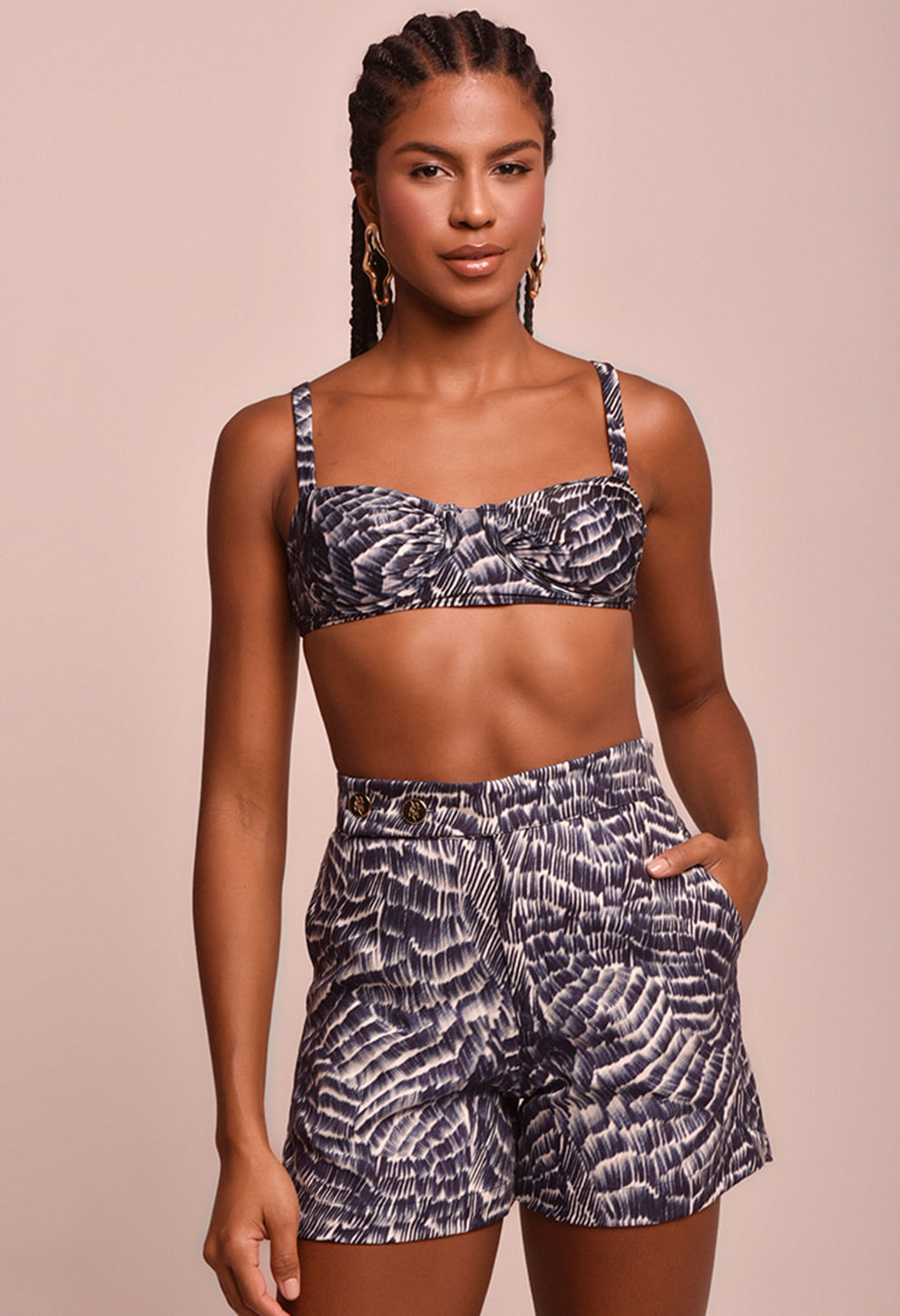Modelo usando Short Brena Maré Alta estampado em tons azul escuro, branco e cinza, com cós alto e dois botões dourados