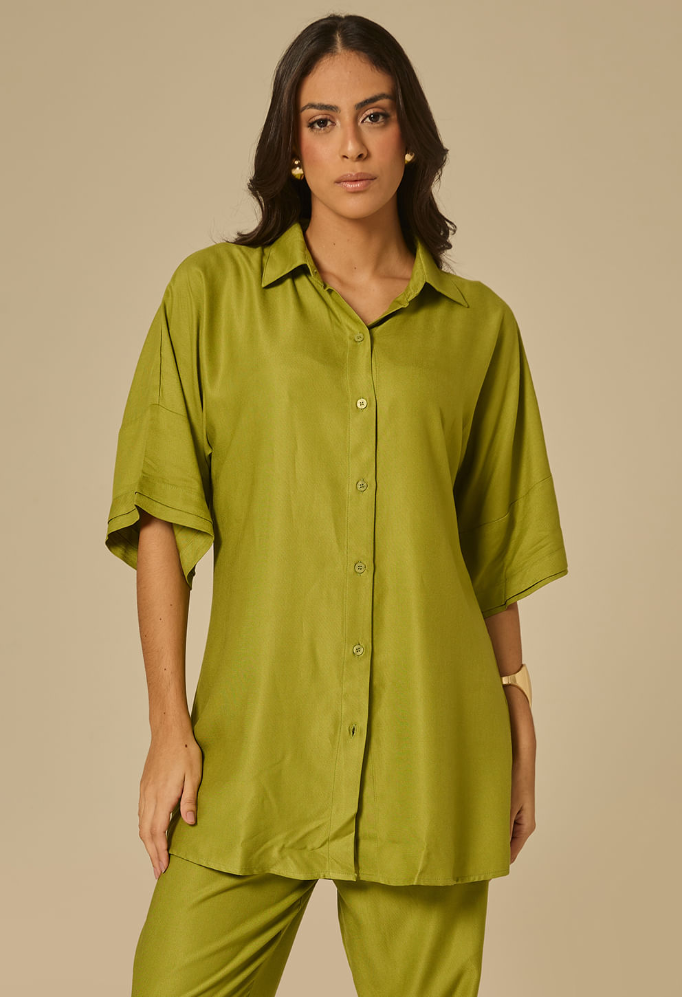 Modelo feminina vestindo camisão longo em tom esmeralda, com botões frontais e mangas 3/4 amplas.