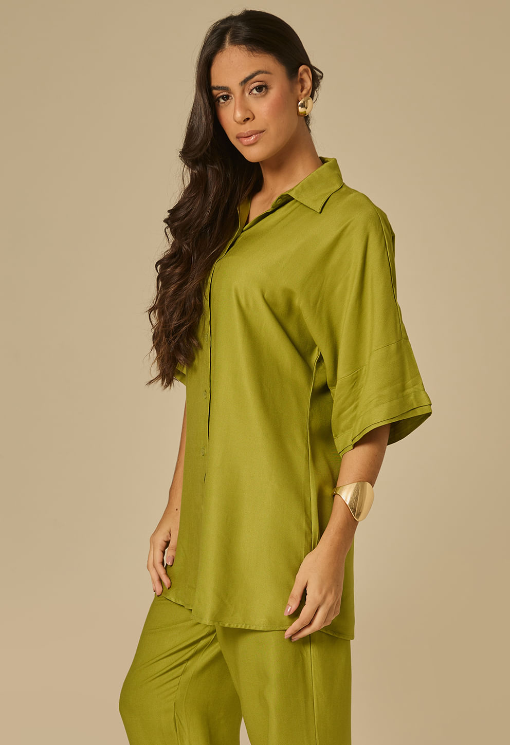 Perfil do camisão esmeralda mostrando caimento oversized e gola clássica.