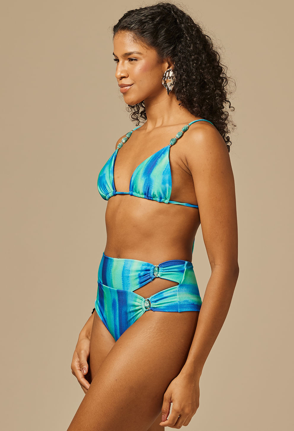 Modelo lateral usando top de biquíni azul com pedras boreais e efeito tie-dye